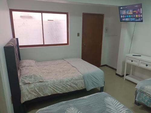 a bedroom with two beds and a window at Hostal O'Higgins in Los Andes
