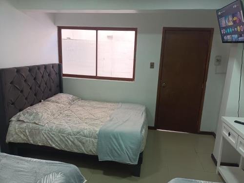 a small bedroom with two beds and a window at Hostal O'Higgins in Los Andes
