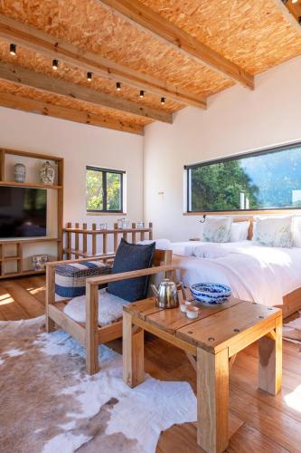 a bedroom with a bed and a coffee table at Granite Forest Chalet in Cape Town