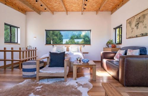 a living room with a couch and a bed at Granite Forest Chalet in Cape Town