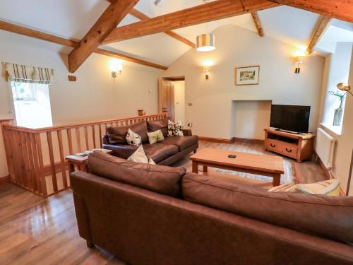a living room with leather couches and a flat screen tv at Abbots Reading Cottage in Lakeside
