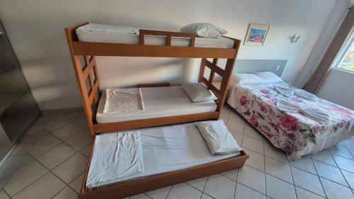 two bunk beds in a room with a bed at Hotel Kolman in Capão da Canoa