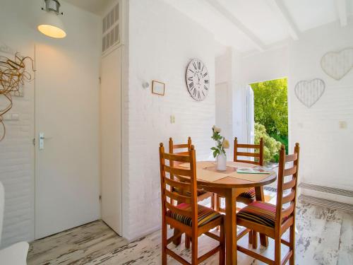 a dining room with a wooden table and chairs at Bungalow in Noordwijk near Beaches in Noordwijkerhout