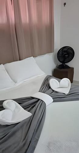 a bed with two white hearts on top of it at Flat beira-mar Natal in Natal