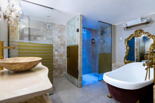 a bathroom with a tub and a sink and a shower at Elegance East Hotel in Antalya