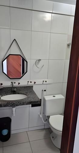 a bathroom with a sink and a toilet and a mirror at Flat beira-mar Natal in Natal