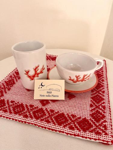 a pair of bowls and a cup on a table at Note Sulla Piazza in Cagliari