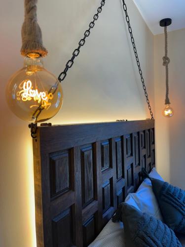 aendant light and a bed with a wooden head board at VILLA KALMA by Almastur Rural 