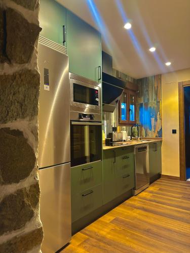 a kitchen with stainless steel appliances and a stone wall at VILLA KALMA by Almastur Rural 
