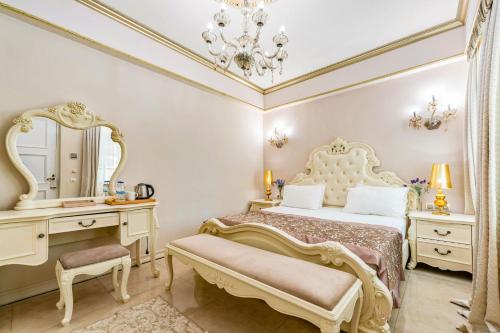 a bedroom with a bed and a vanity and a mirror at Elegance East Hotel in Antalya