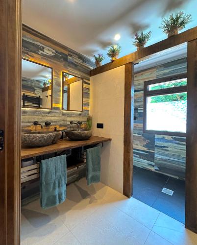 a bathroom with two sinks and a mirror at VILLA KALMA by Almastur Rural 