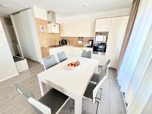 Una cocina y un comedor con una mesa y sillas blancas. en Apartmán Fatranská,Parking Free ,Air Condition, en Košice