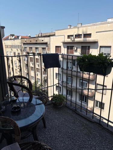 a balcony with a table and chairs and a building at Apartments Sat in Belgrade