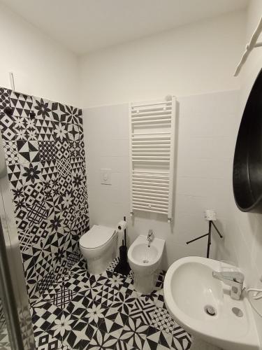 a bathroom with a white toilet and a sink at Il Glicine 2 in Castelmezzano