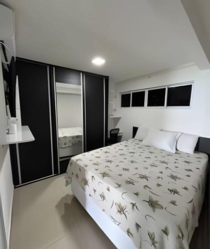 a bedroom with a large bed and a large window at Flat praia a beira-mar in Natal