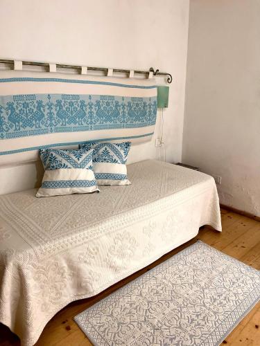 a bed with a blue and white headboard and a rug at Note Sulla Piazza in Cagliari