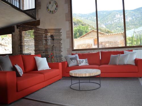 a living room with a red couch and a table at Belvilla by OYO Cobert de l'Era in Oden