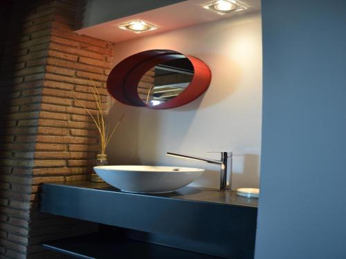 a bathroom with a bowl sink and a red mirror at Belvilla by OYO Cobert de l'Era in Oden