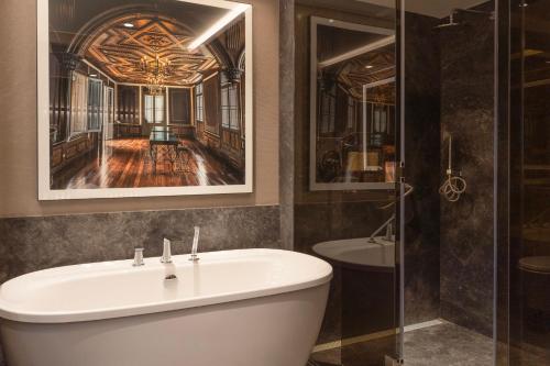 a bathroom with a tub and a shower and a sink at InterContinental Hotels Real Lima Miraflores by IHG in Lima