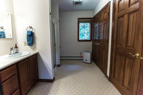 a bathroom with a sink and a mirror and a door at Juneau Hideaway-Glaciers-5 min to downtown- Hiking in Juneau