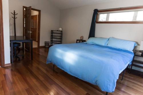 a bedroom with a large bed and a desk at Juneau Hideaway-Glaciers-5 min to downtown- Hiking in Juneau