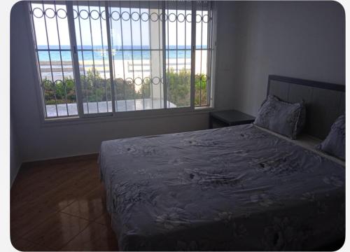 a bedroom with a bed with a view of the ocean at Villa Sounine in Raʼs al Jabal