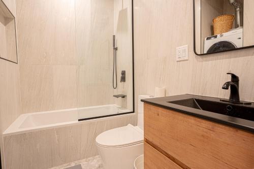 a bathroom with a sink and a toilet and a bath tub at Chic & Modern 3BR Retreat in the Heart of Brooklyn in Brooklyn