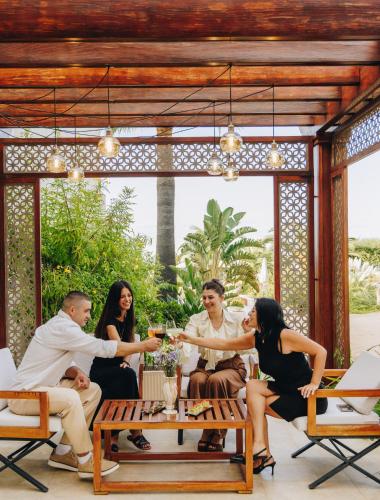 a group of people sitting around a table on a patio at Hotel Corsica & Spa Serena in Calvi