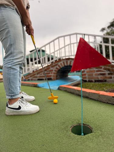 a person playing a game of golf on a putting course at Hotel Entre Lomas in Santa Rosa de Cabal