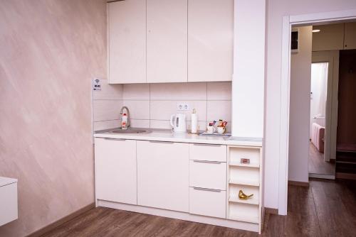 a kitchen with white cabinets and a sink at Royal Imperial in Doboj