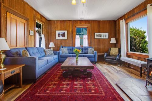 a living room with blue couches and a table at Headlands View Home in Mendocino