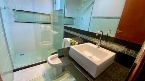 a bathroom with a sink and a toilet at Vale - Suítes Exclusivas (Bairro Nobre) in São Lourenço