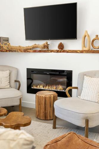 a living room with a fireplace with a flat screen tv at Desert Contemporary Compound - Large Modern Oasis in Joshua Tree