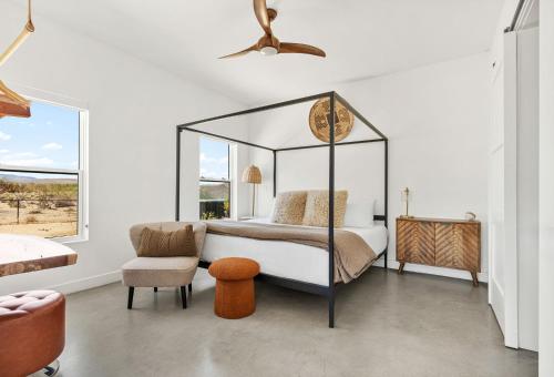 a bedroom with a canopy bed and a chair at Desert Contemporary Compound - Large Modern Oasis in Joshua Tree