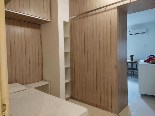 a bedroom with a closet with a bed and a refrigerator at FLATS VISTA MAR e FRENTE MAR NA PRAIA DOS CARNEIROS in Praia dos Carneiros