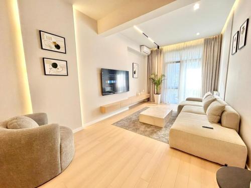 a living room with a couch and a tv at Luxury apartment Saburtalo view in Tbilisi City