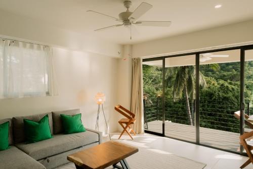 ein Wohnzimmer mit Couch und großem Fenster in der Unterkunft Solana in Bahías de Huatulco