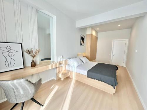 a bedroom with a bed and a desk and a chair at Luxury apartment Saburtalo view in Tbilisi City