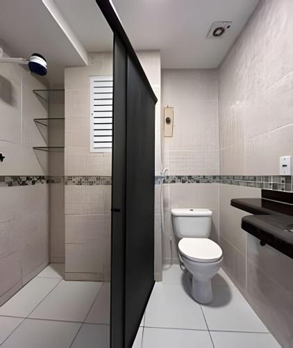 a bathroom with a toilet and a shower at Flat à beira-mar com vista para a praia do meio in Natal