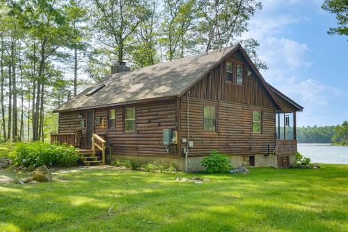 a log cabin on the shore of a lake at Lakeside Log Cabin with Porch in Monadnock Region in Rindge