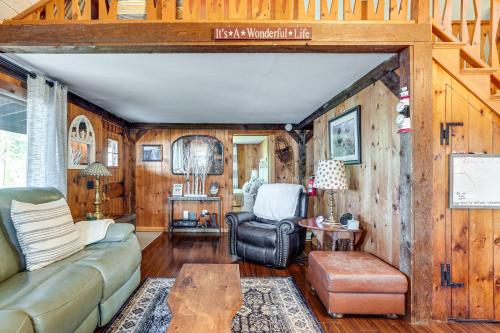 a living room with a couch and a table at Lakeside Log Cabin with Porch in Monadnock Region in Rindge
