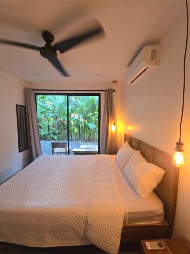 a bedroom with a bed and a large window at Villa Pecho Amarillo in Fortuna