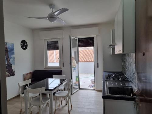 a kitchen with a table and chairs and a dining room at Bilocale nuovo, attrezzato con bel terrazzo a 2 passi dal mare in Tortoreto Lido