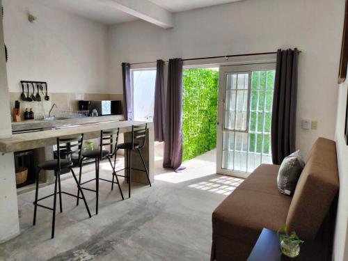 a kitchen and living room with a bar and a couch at Departamento Tulipan Puerto Vallarta in Puerto Vallarta