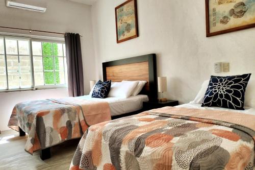 a bedroom with two beds and a window at Departamento Tulipan Puerto Vallarta in Puerto Vallarta