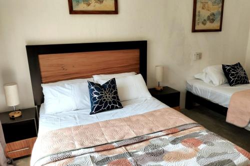 a bedroom with a bed and two tables with lamps at Departamento Tulipan Puerto Vallarta in Puerto Vallarta