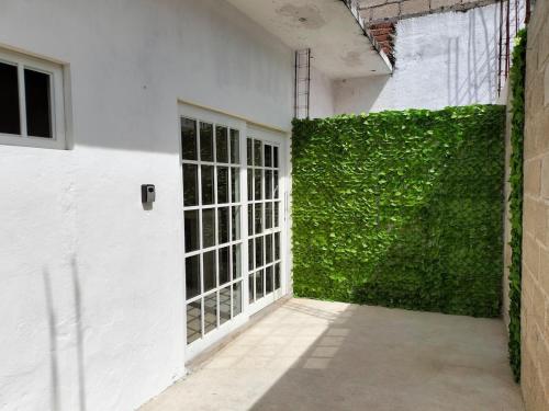 a white building with a green wall next to a door at Departamento Tulipan Puerto Vallarta in Puerto Vallarta