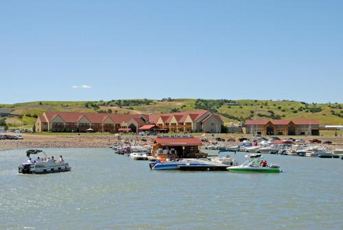 a group of boats in the water near a beach at Cedar Shore Resort in Oacoma