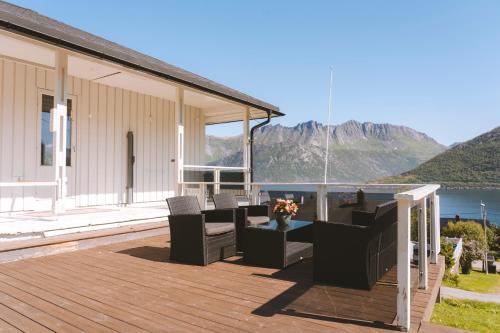 a deck with chairs and a table on a house at Spacious Waterfront Gem - Panoramic View - Terrace in Fjordgård