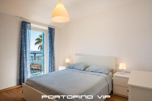 a bedroom with a bed and a window with a view at Dipinto di blù by PortofinoVip in Santa Margherita Ligure